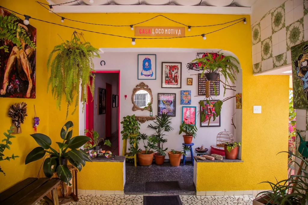 Entrada da Casa Locomotiva com plantas e obras de arte