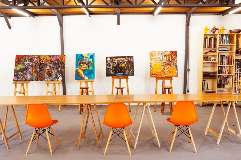 Parede de obras e mesa de trabalho no ateliê