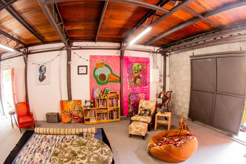 Ateliê com quadros, tapete e área de convivência